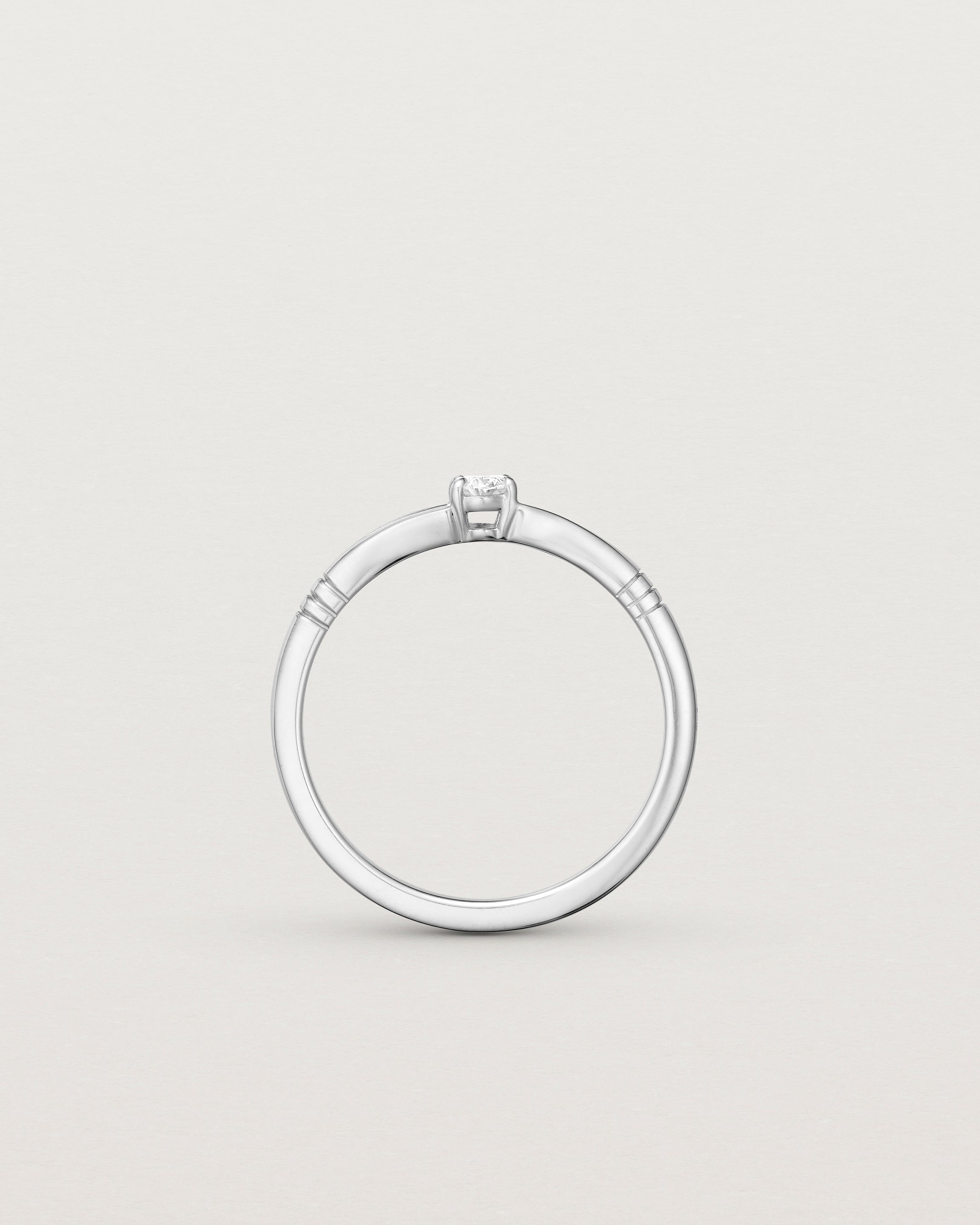 Standing deep etched image of a white gold engagement ring with an oval diamond.