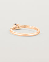 Back facing deep etched image of a rose gold engagement ring with an oval sapphire stone