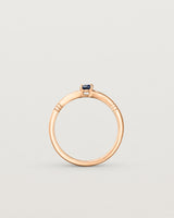 Standing deep etched image of a rose gold engagement ring with an oval sapphire stone