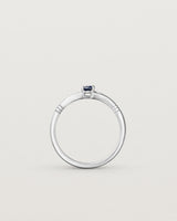 Standing deep etched image of a white gold engagement ring with an oval sapphire stone