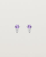 Front facing deep etched image of a pair of white gold earrings with amethyst birthstones and diamonds.