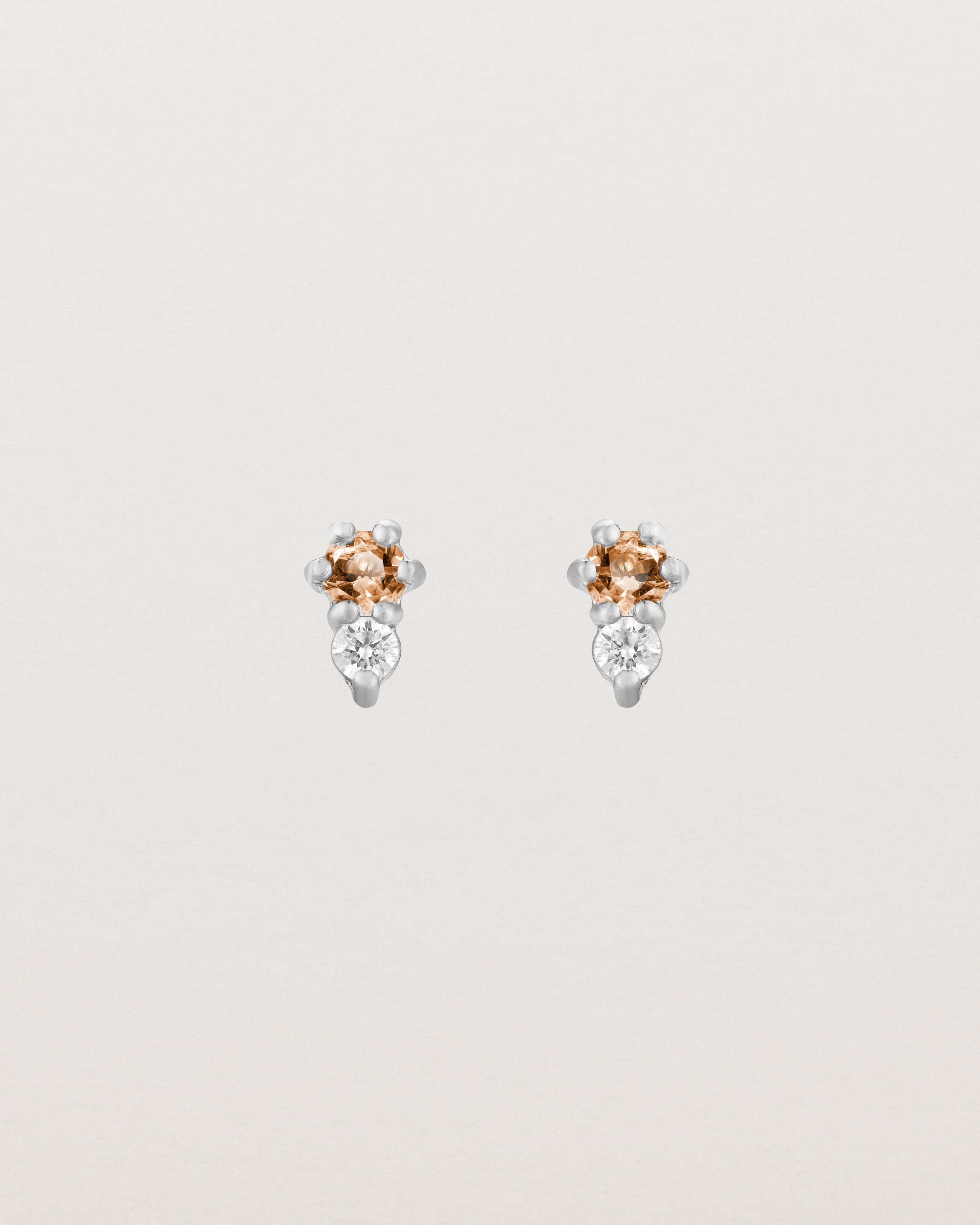 Front facing deep etched image of a pair of white gold earrings with citrine birthstones and diamonds.