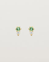 Front facing deep etched image of a pair of yellow gold earrings with emerald birthstones and diamonds.