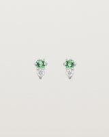 Front facing deep etched image of a pair of white gold earrings with emerald birthstones and diamonds.