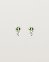 Front facing deep etched image of a pair of white gold earrings with peridot birthstones and diamonds.