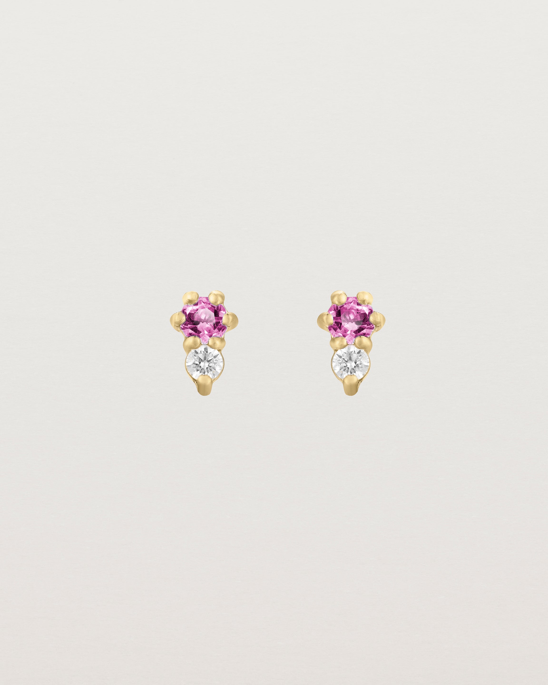 Front facing deep etched image of a pair of yellow gold earrings with pink tourmaline birthstones and diamonds.