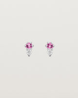 Front facing deep etched image of a pair of white gold earrings with pink tourmaline birthstones and diamonds.