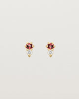 Front facing deep etched image of a pair of yellow gold earrings with ruby birthstones and diamonds.