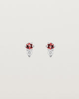 Front facing deep etched image of a pair of white gold earrings with ruby birthstones and diamonds.