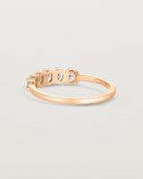 Back facing deep etched image of a rose gold wrap engagement ring with five oval diamonds.