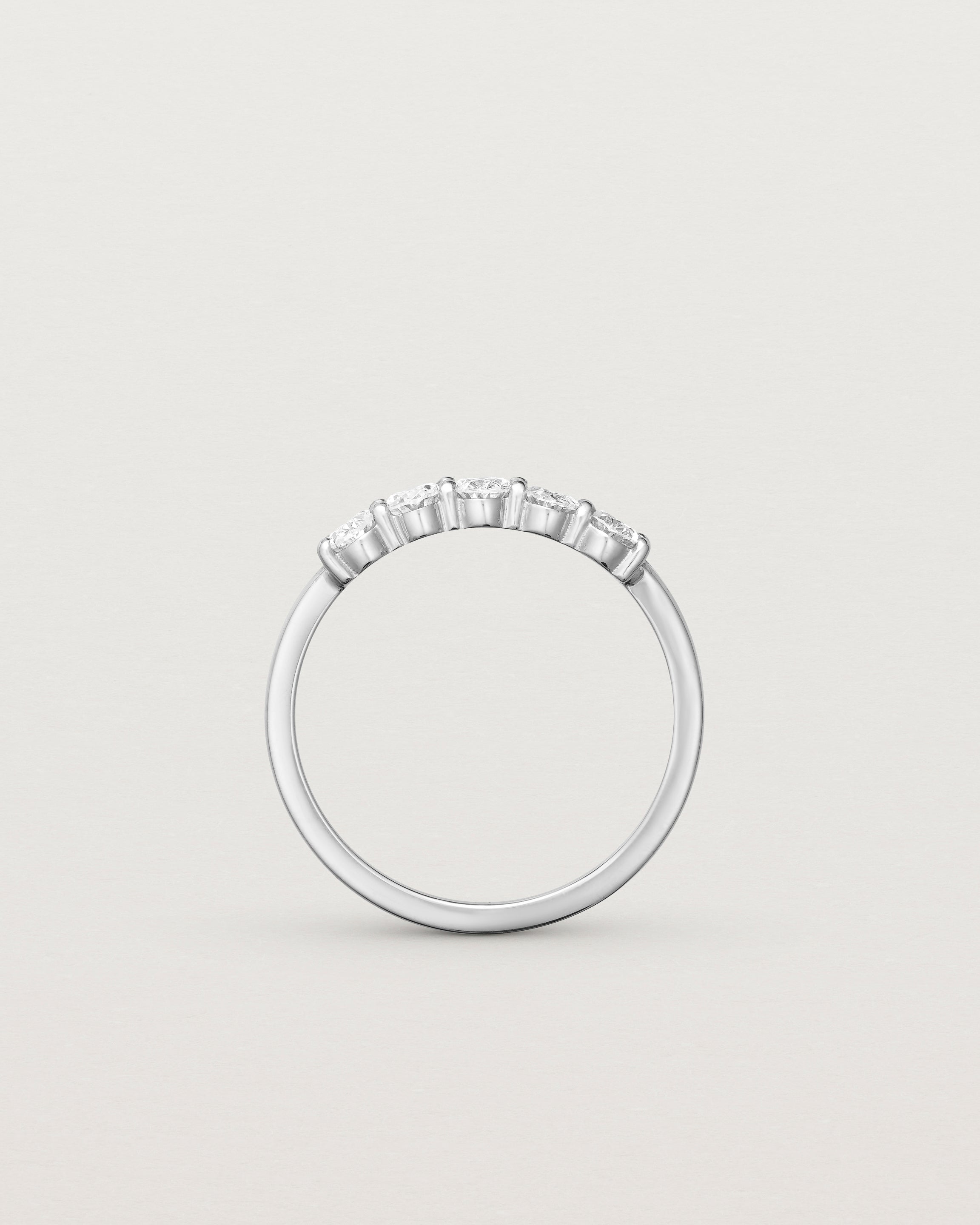 Standing deep etched image of a white gold wrap engagement ring with five oval diamonds.