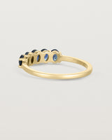 Back facing  deep etched image of a yellow gold wrap engagement ring with five Sapphire Stones.