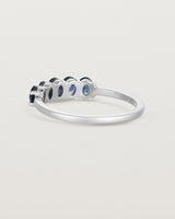 Back facing deep etched image of a white gold wrap engagement ring with five Sapphire Stones.