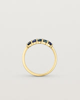 Standing deep etched image of a yellow gold wrap engagement ring with five Sapphire Stones.