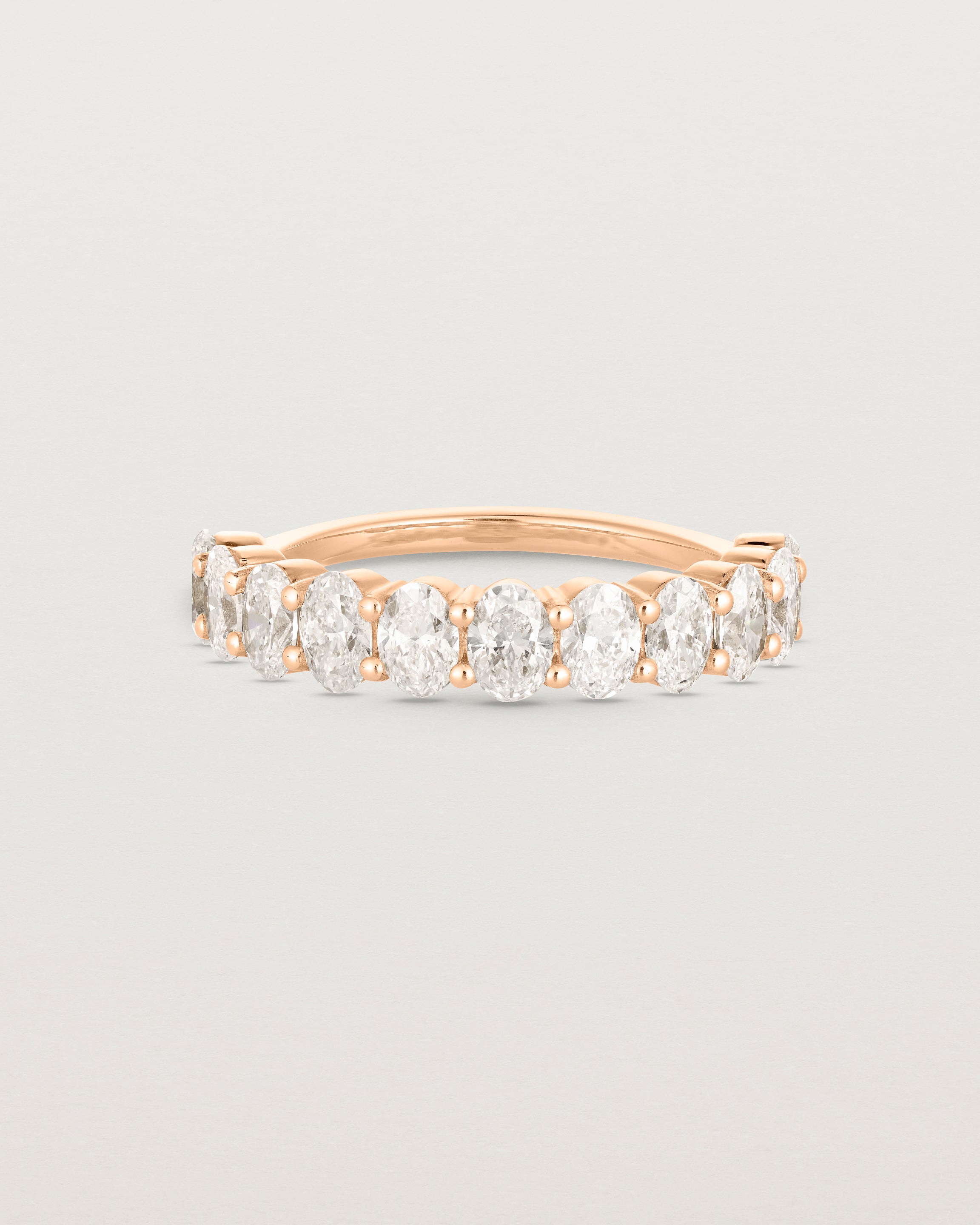 Front on deep etched image of a rose gold wrap engagement ring with 11 white diamonds.