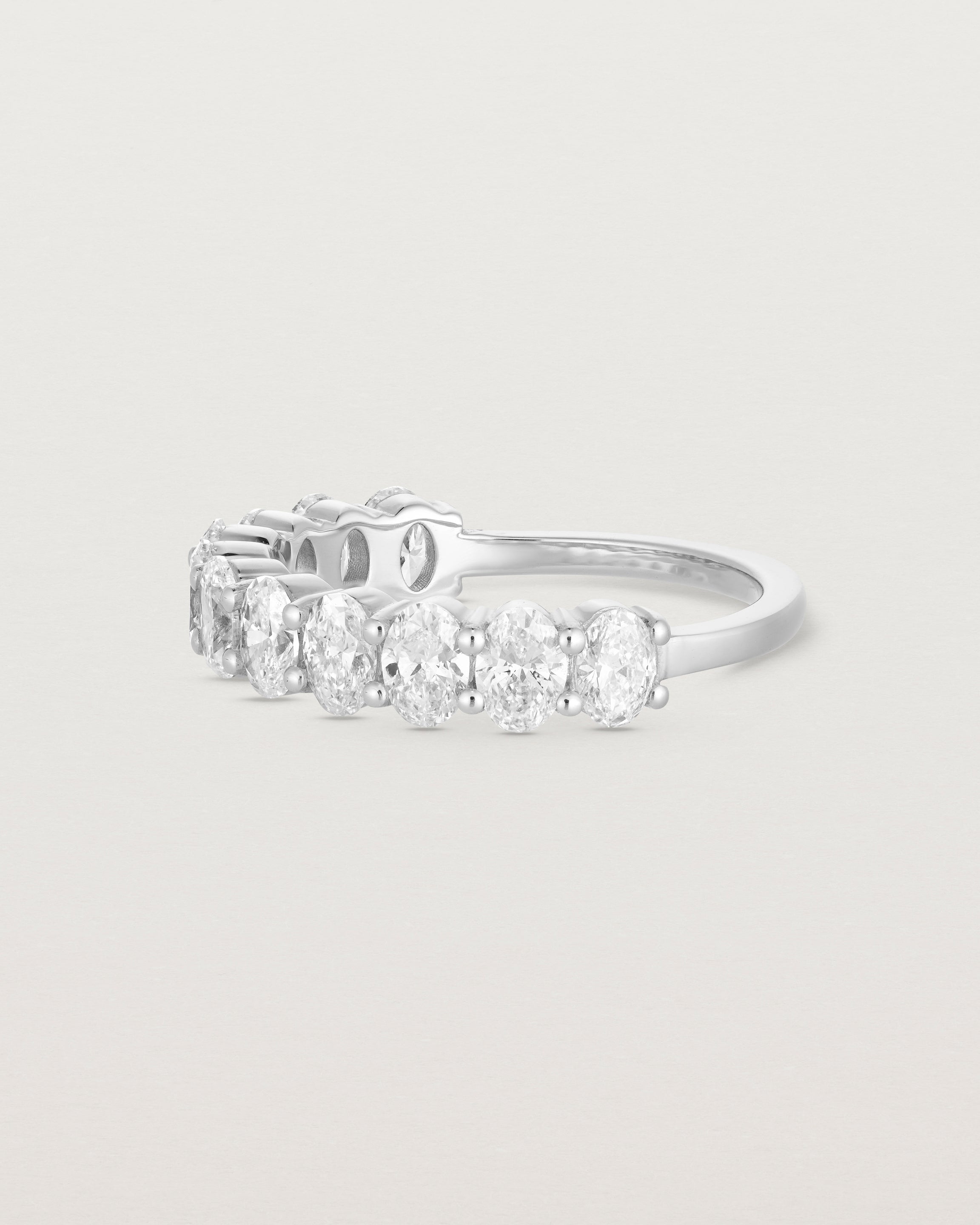 side on deep etched image of a white gold wrap engagement ring with 11 white diamonds.