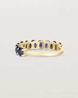 back facing deep etched image of a yellow gold wrap engagement ring with 11 sapphire stones.