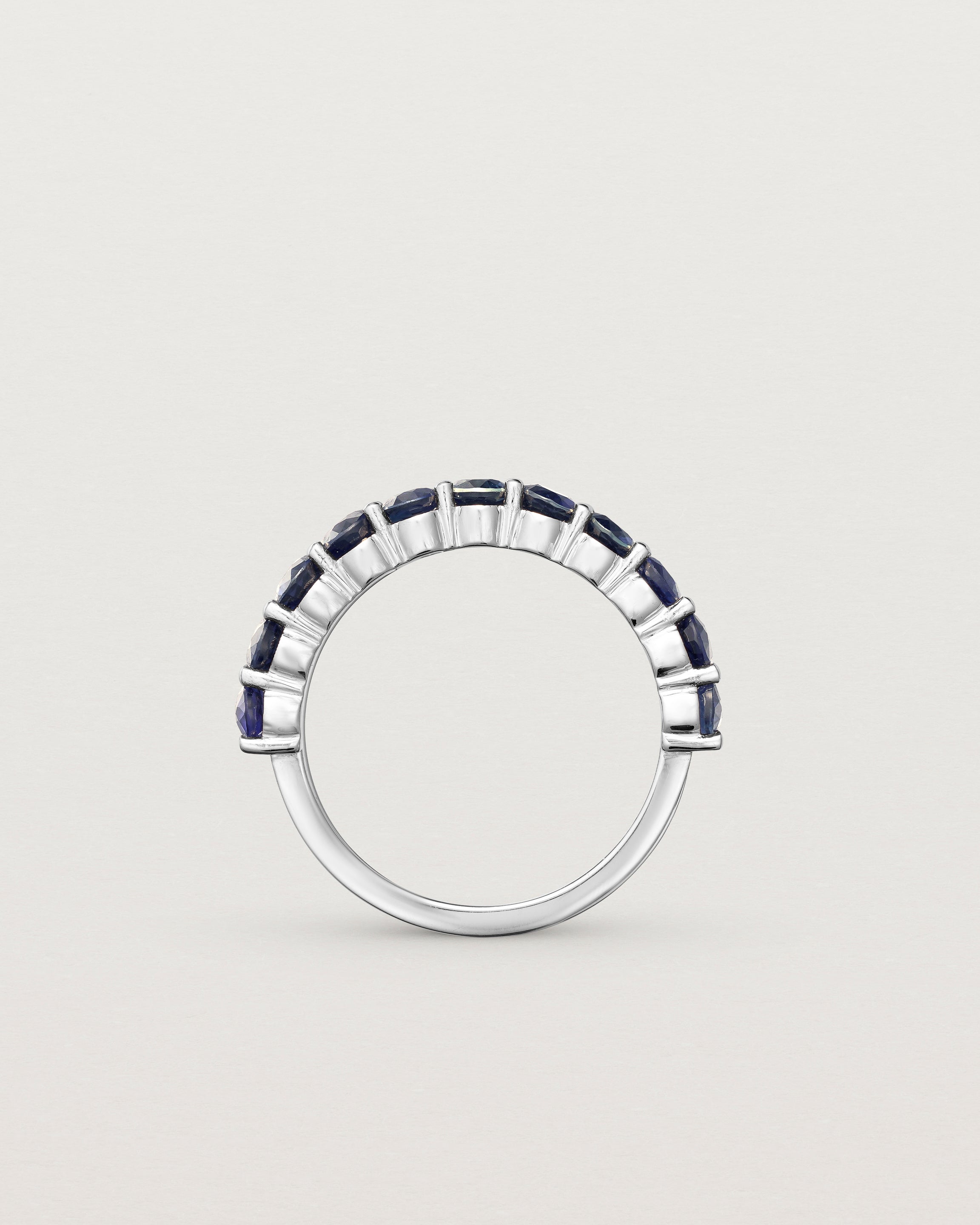 standing deep etched image of a white gold wrap engagement ring with 11 sapphire stones.