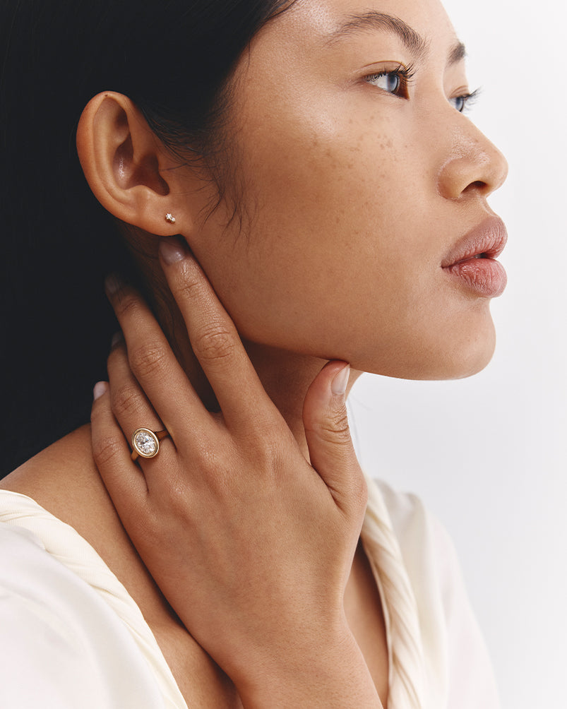 image of a  woman wearing yellow gold oval diamond engagement ring