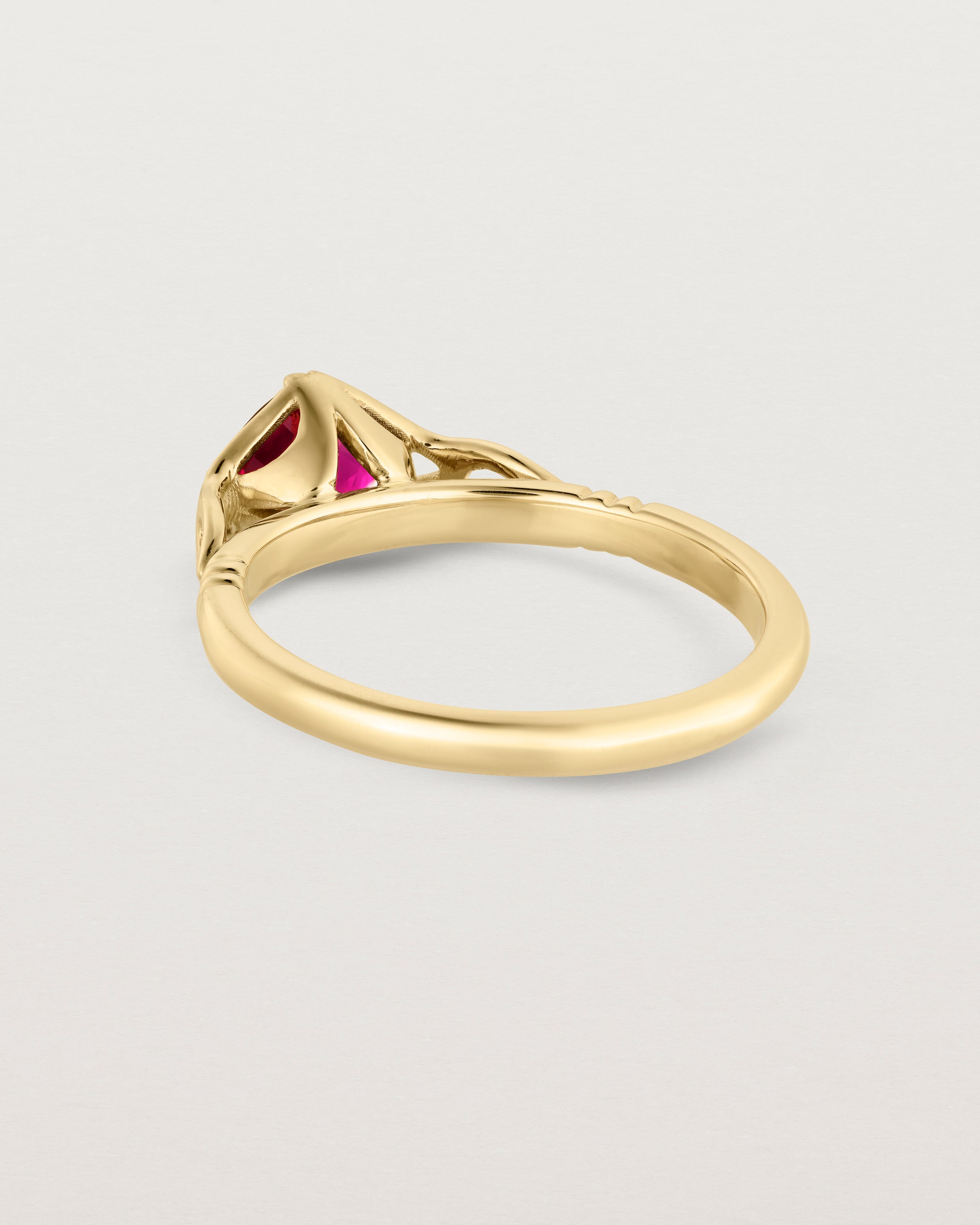 Back facing deep etched image of a yellow gold vintage inspired ring with a cushion cut ruby.