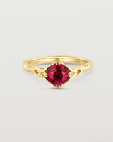 Front facing deep etched image of a yellow gold vintage inspired ring with a cushion cut ruby.