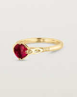 Side facing deep etched image of a yellow gold vintage inspired ring with a cushion cut ruby.