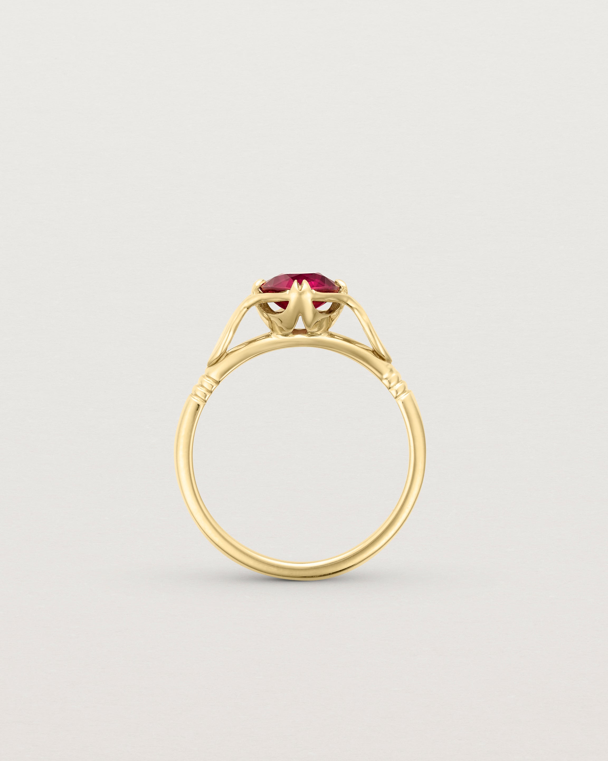 Standing deep etched image of a yellow gold vintage inspired ring with a cushion cut ruby.