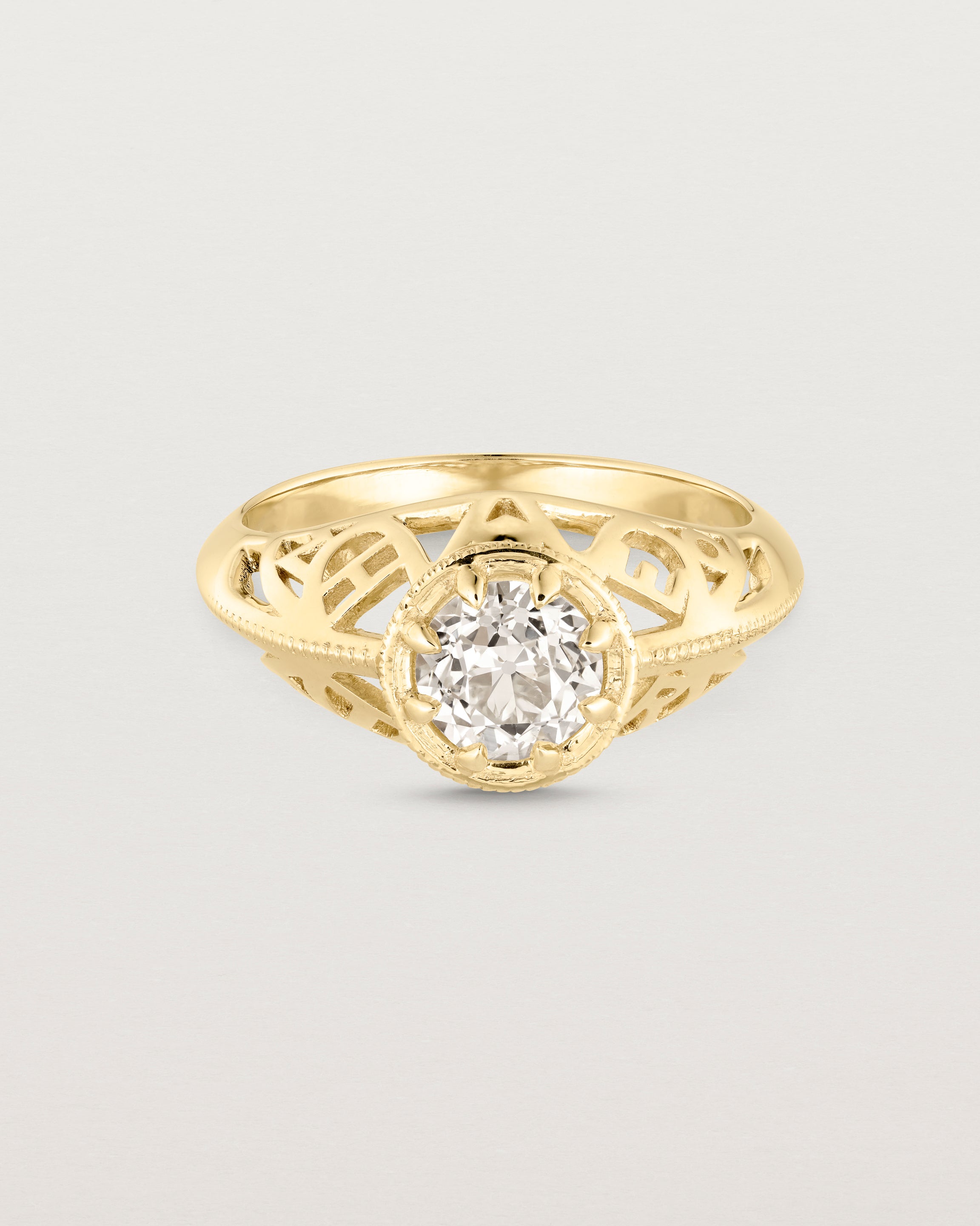 Front facing deep etched image of a yellow gold vintage inspired ring with old mine cut diamond, framed by an intricate filagree inspired gallery.