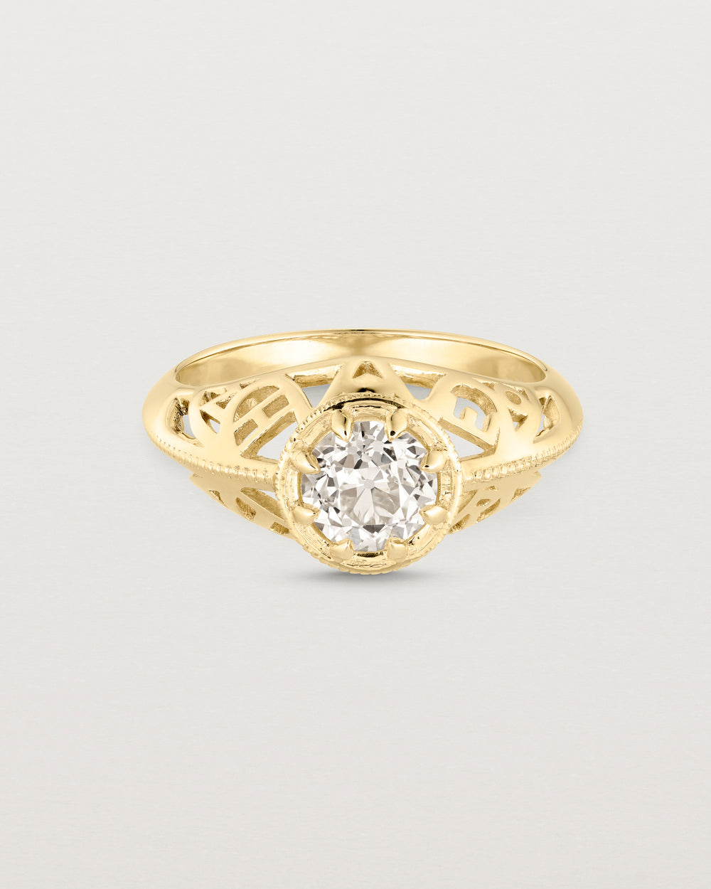 Front facing deep etched image of a yellow gold vintage inspired ring with old mine cut diamond, framed by an intricate filagree inspired gallery.