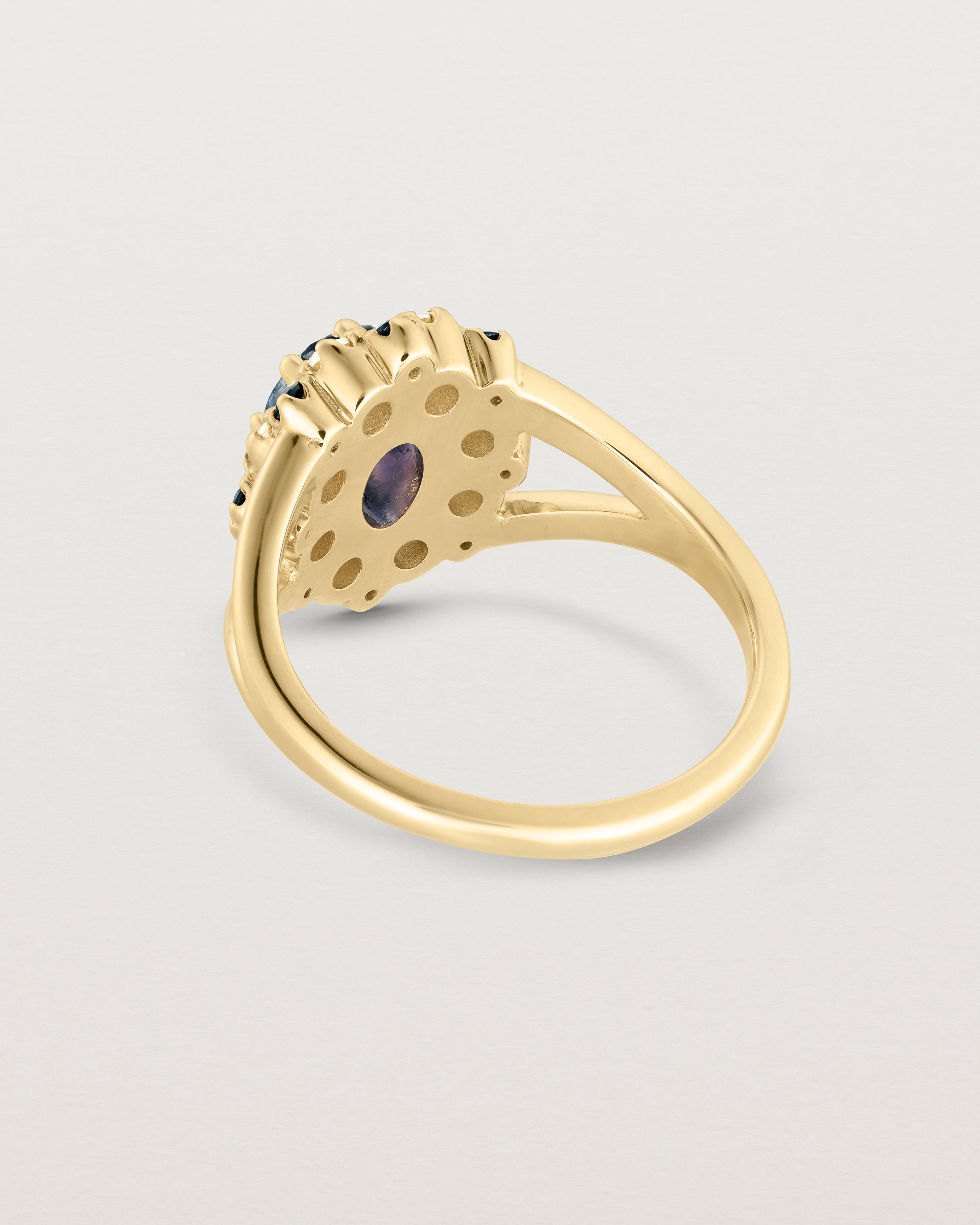 Back facing deep etched image of a yellow gold vintage inspired ring with an oval Ceylon Sapphire and a tiered halo of Old Cut Diamonds and Australian Sapphires.