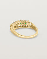 Back facing deep etched image of a yellow gold vintage inspired wrap ring with seven green emeralds and a graduation of 18 old cut diamonds.