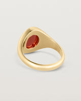 Back facing deep etched image of a yellow gold signet ring with carnelian.