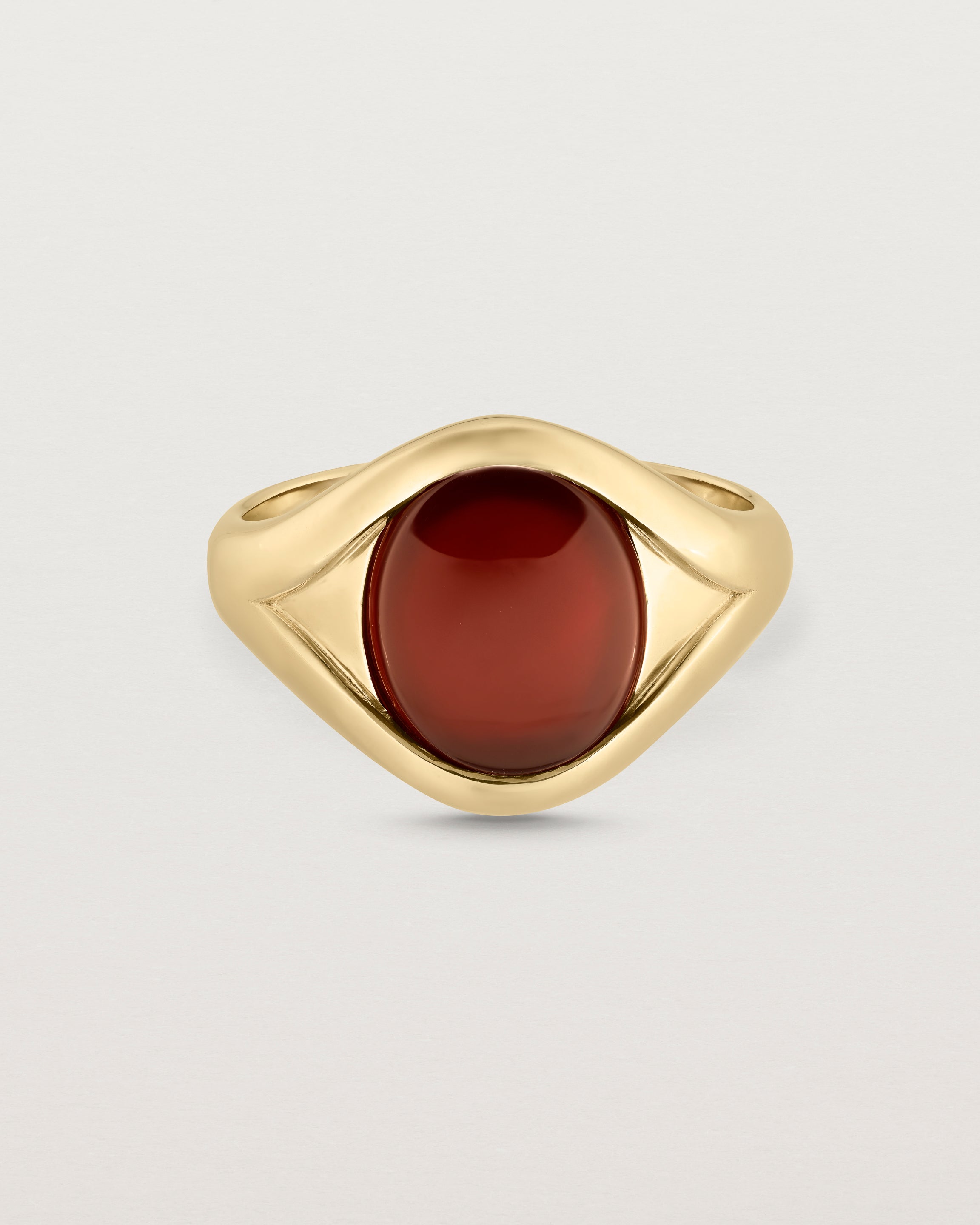 Front facing deep etched image of a yellow gold signet ring with carnelian.