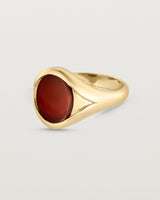 Side facing deep etched image of a yellow gold signet ring with carnelian.