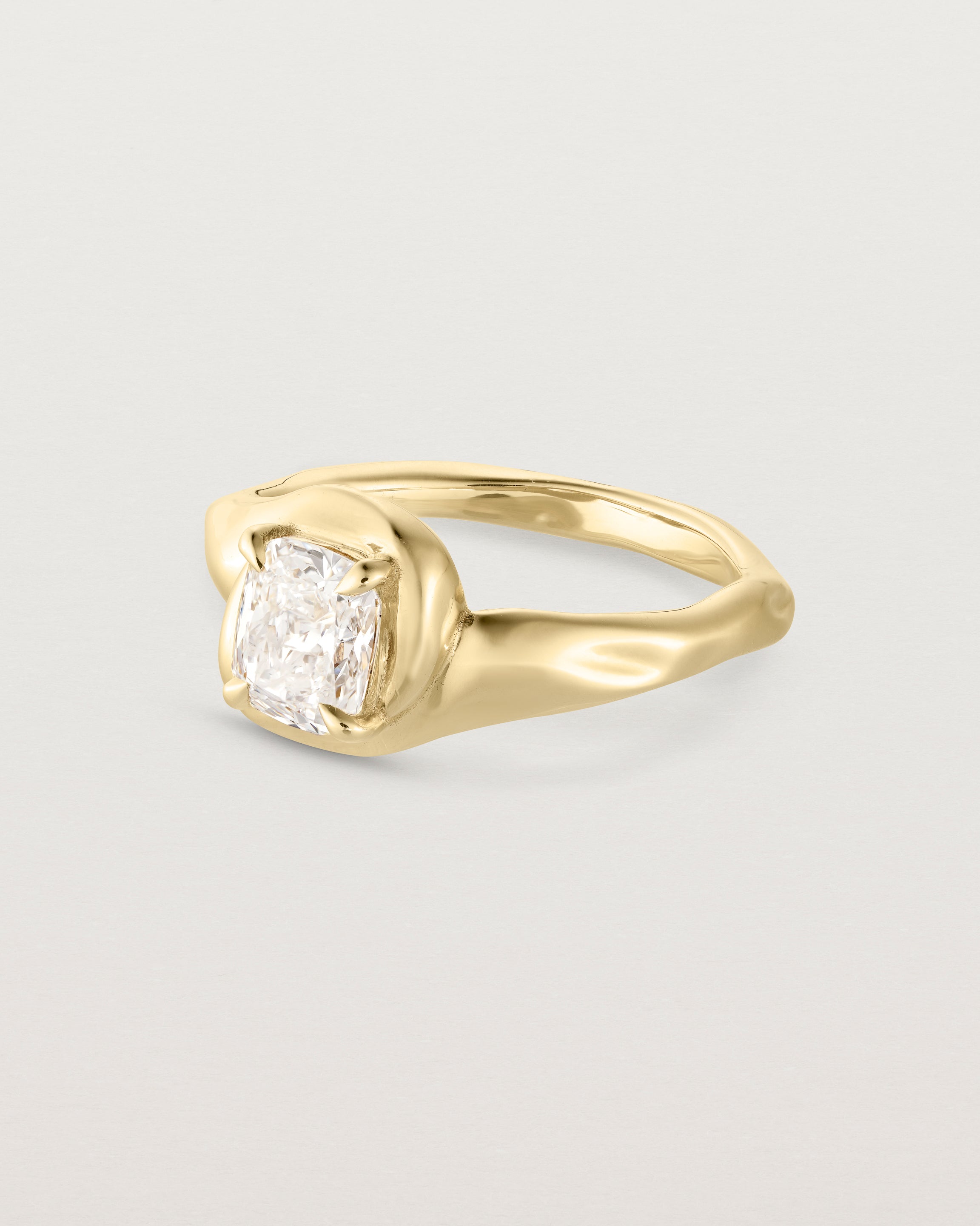 Side facing deep etched image of a yellow gold solitaire engagement ring