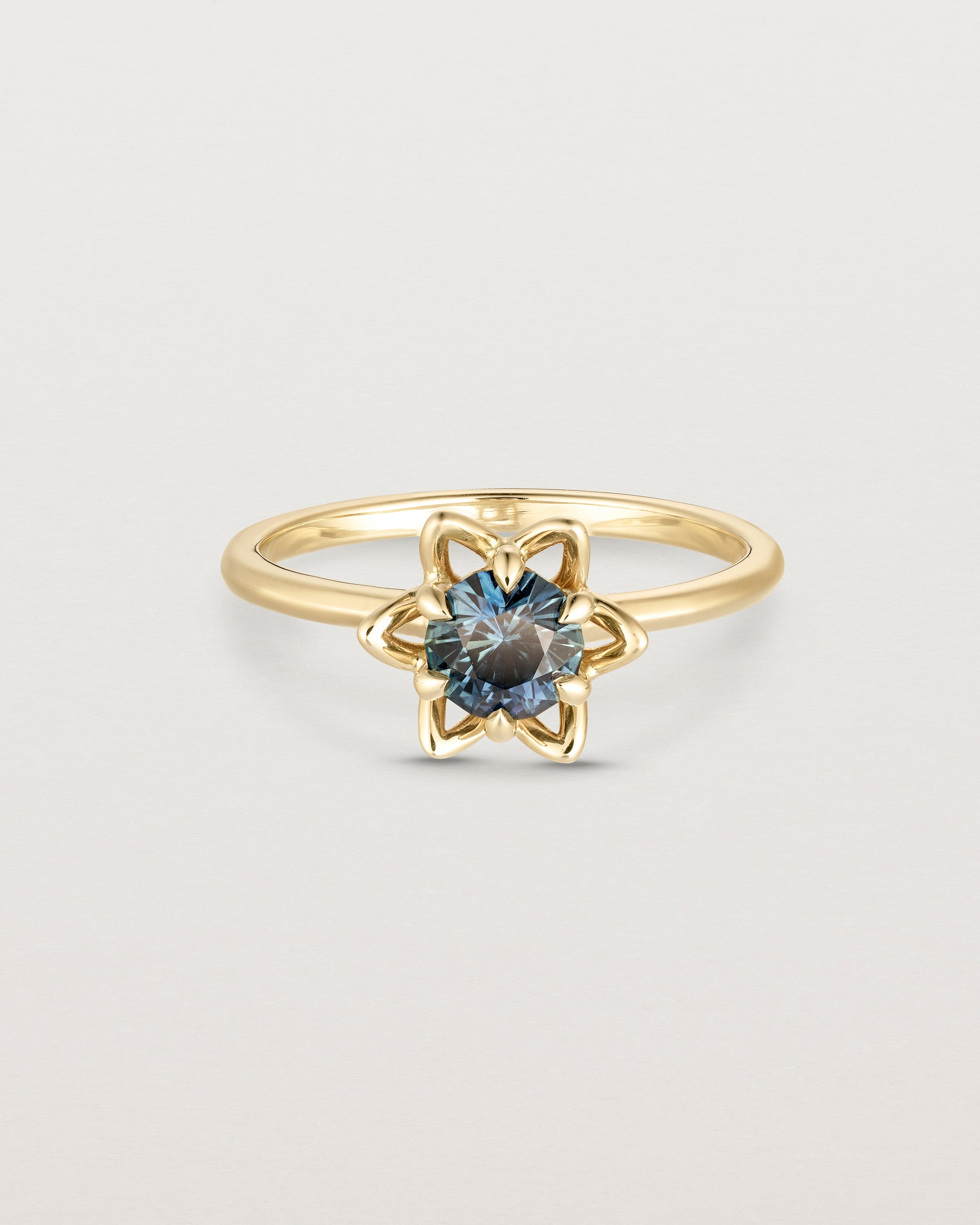 Front facing deep etched image of a Australian Teal Sapphire solitaire engagement ring. 