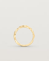 Standing deep etched image of a yellow gold ring with seven scattered white diamonds.