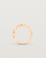 Standing deep etched image of a rose gold ring with seven scattered white diamonds.