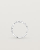 Standing deep etched image of a white gold ring with seven scattered white diamonds.