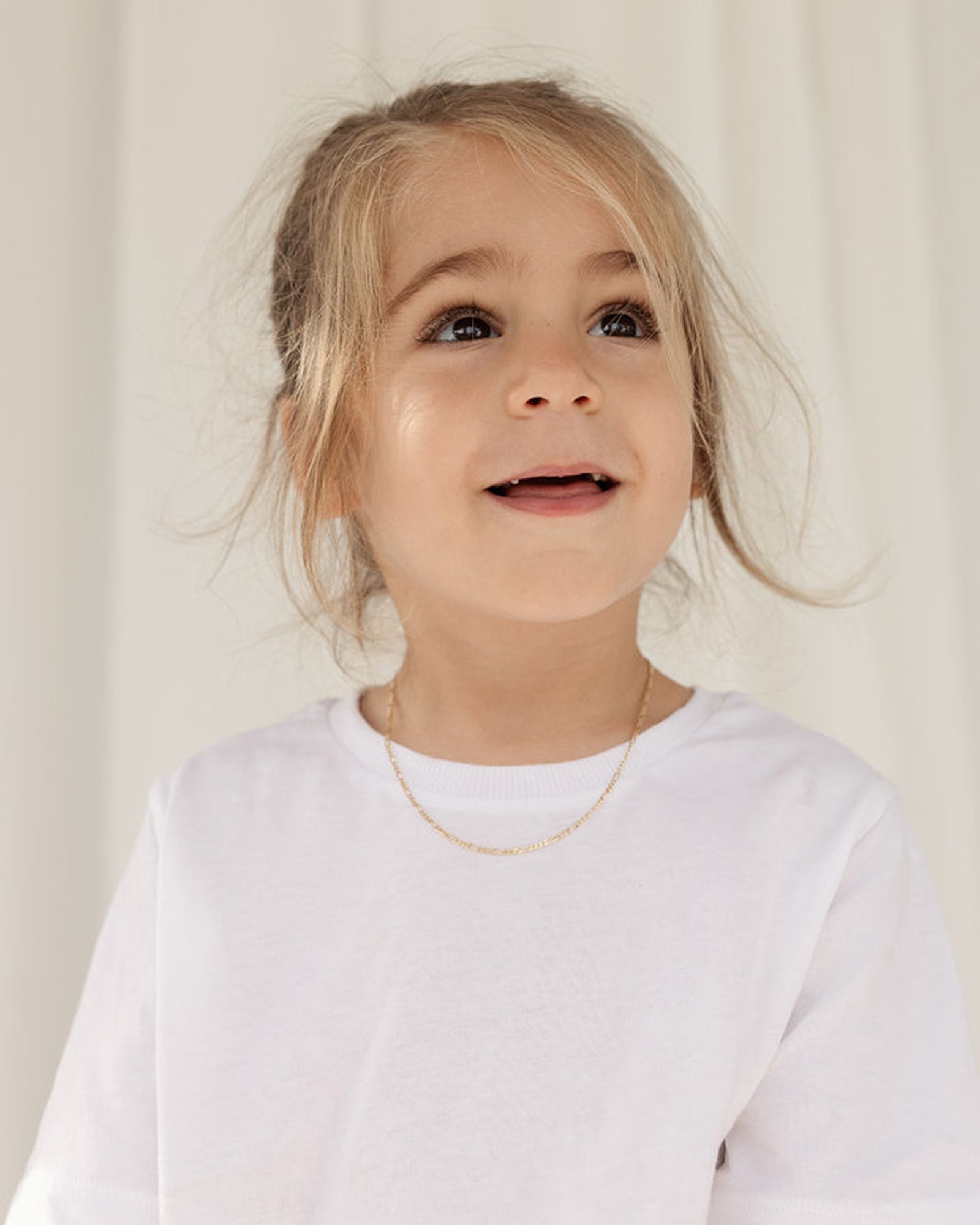 Front of image of the Petit Figaro chain in yellow gold being worn by a boy model