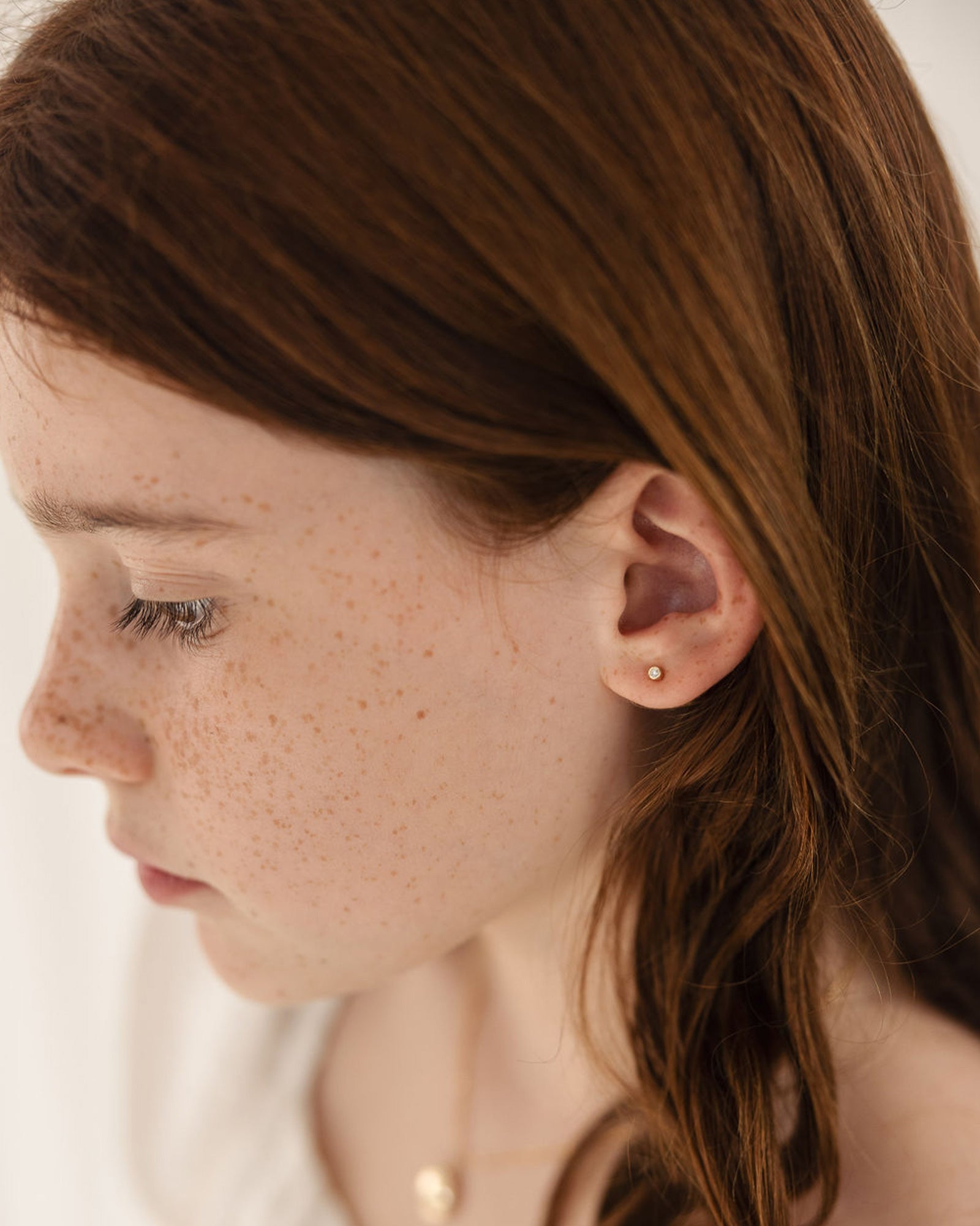 child model wearing the petits cascade diamond studs in yellow gold