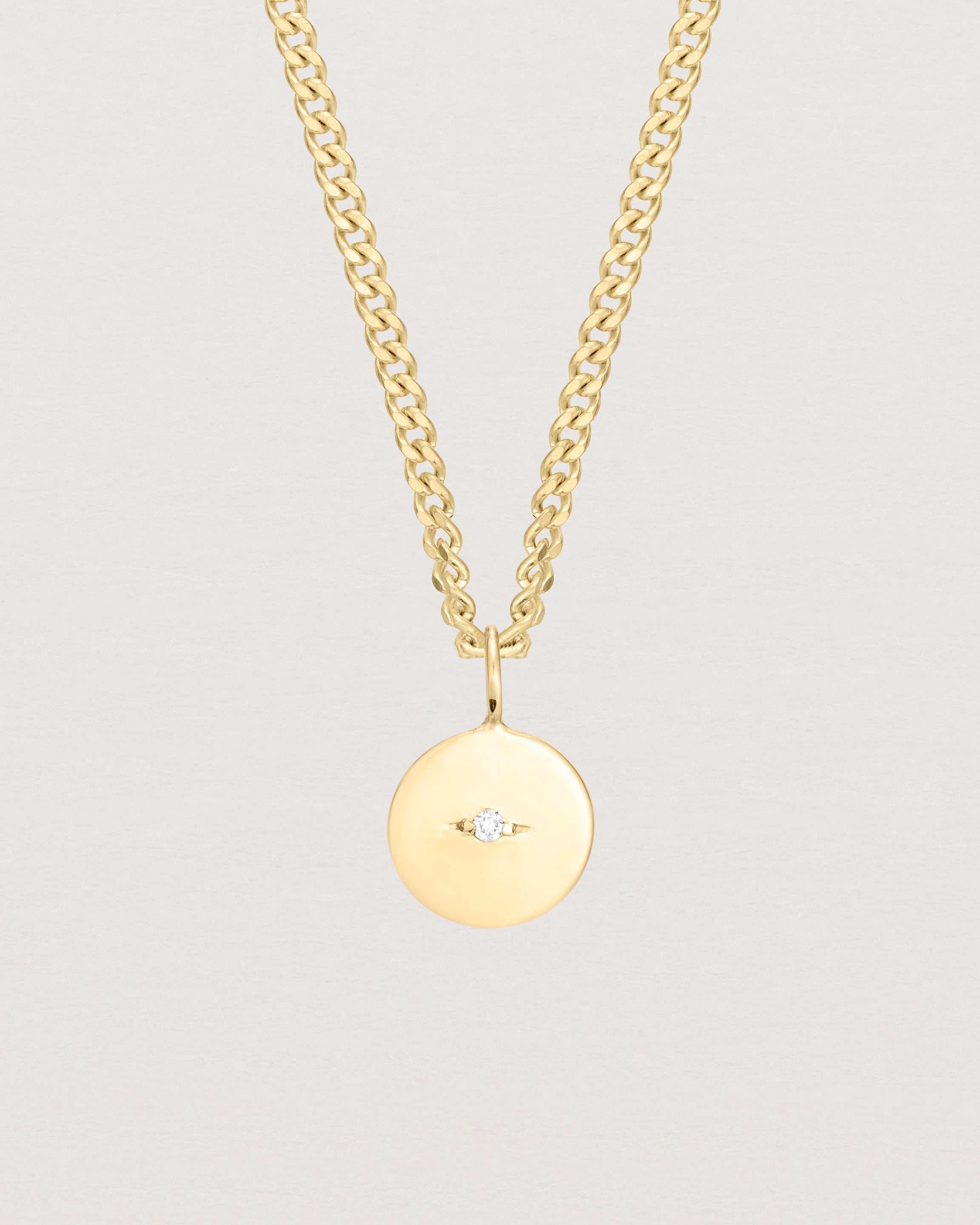 Close up image of the Petits Eily necklace with diamond in yellow gold