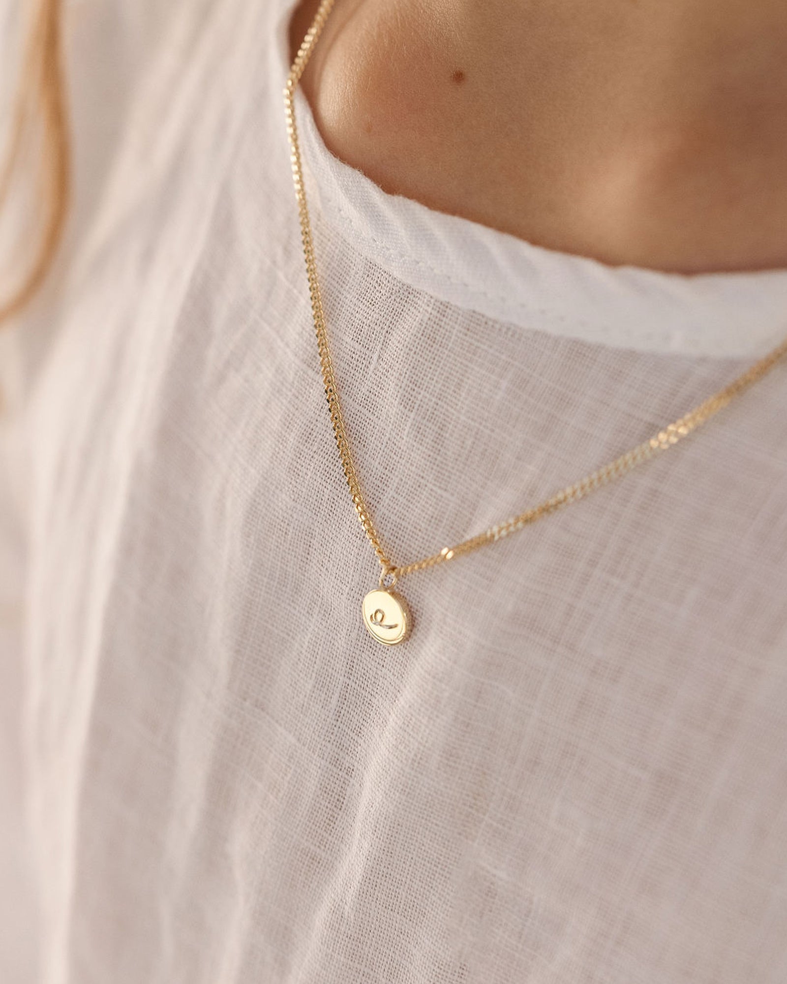 On model image of the Petit Mae Pendant in yellow gold.