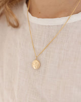 image of the starburst locket in rose gold being worn by a child model.