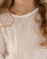 image of the starburst locket in rose gold being worn by a child model.