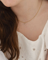close up image of the Starburst Diamond necklace in yellow gold, being worn on a child model