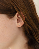 An image of the petit starburst studs with white diamonds shown being worn on a child model