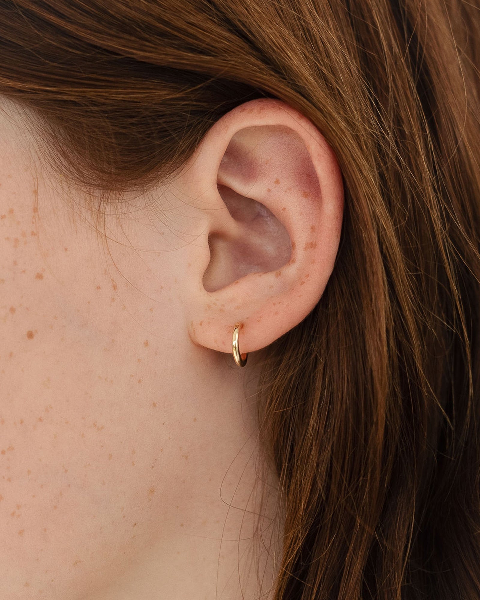 on model image of the petits suspend hoops in yellow gold close up