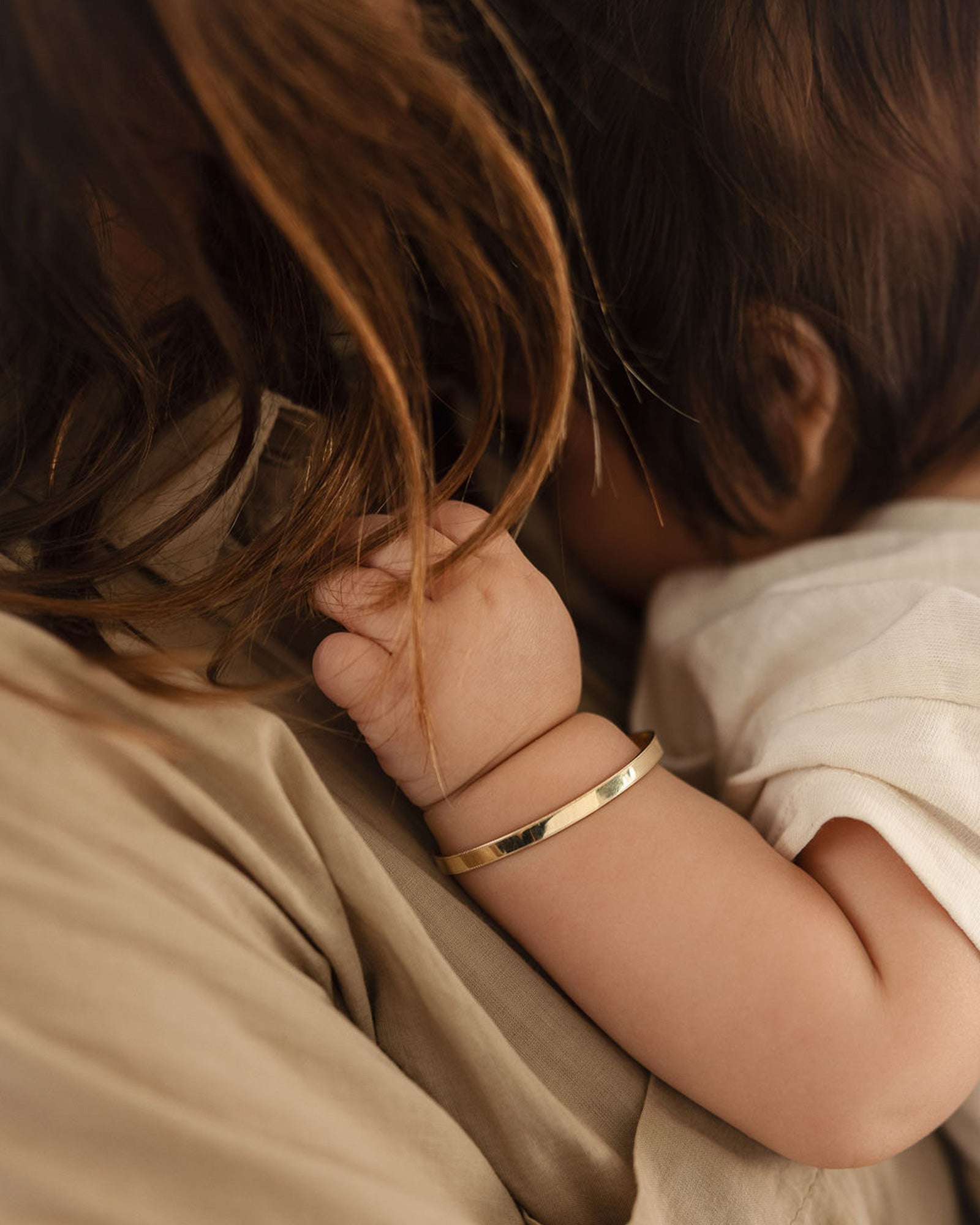 photo of a baby wearing the toujours bangle in yellow gold