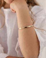 photo of a child wearing the toujours bangle in yellow gold